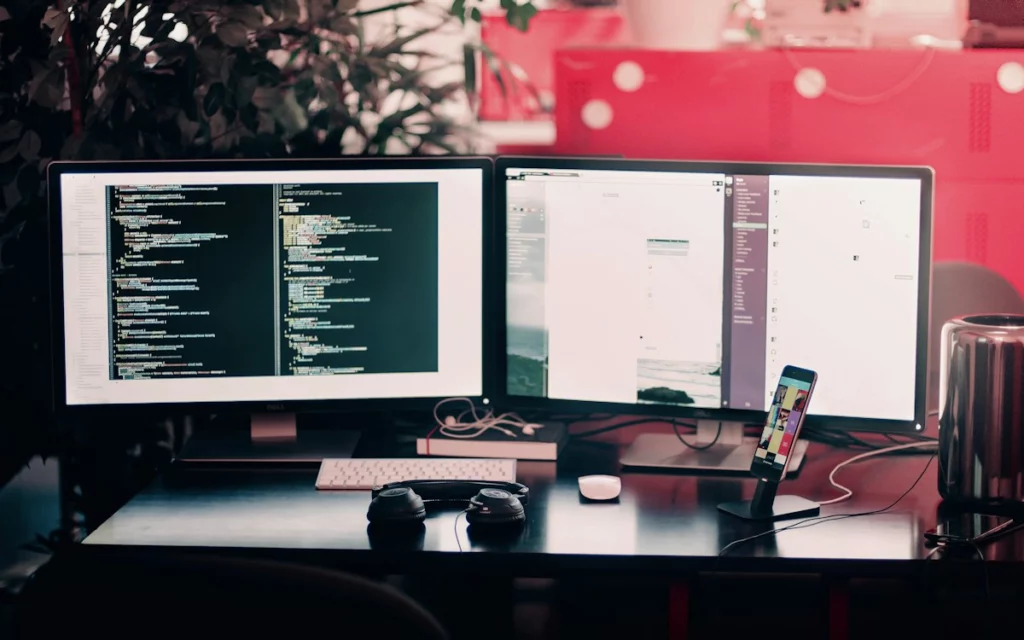 Монитор с поисковой выдачей и редактором кода на рабочем месте SEO-специалиста